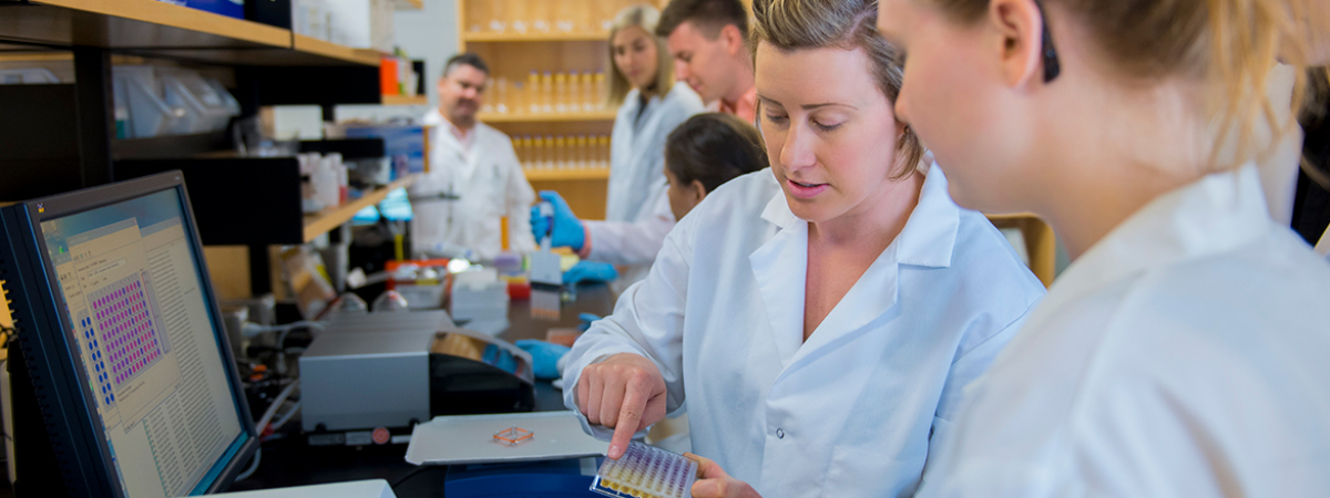 students and instructors examine lab samples