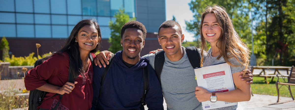 Students Smiling Outside Banner