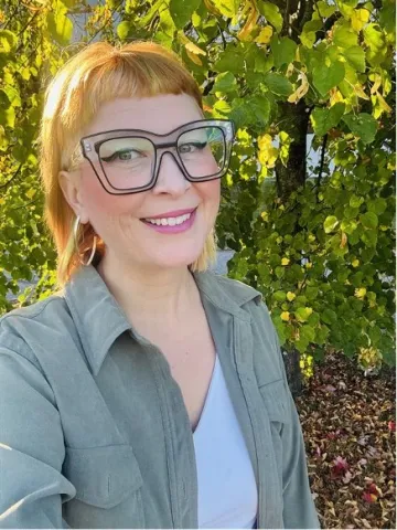 A woman taking a selfie in front of a nature background