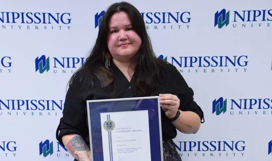 Emily Otowadjiwan with award