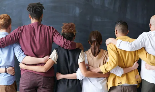 back facing group shot of everyone with their arm's around each other