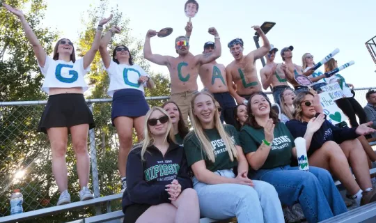 Lakers cheering during games, people in the back row have letters "GO CALLUM" written on them