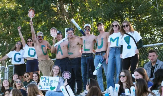 Lakers cheering with painted letters that spell "GO CALLUM!"