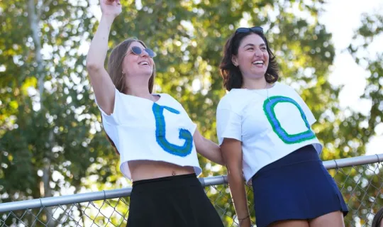 Two Lakers cheering on, shirts spell "GO"