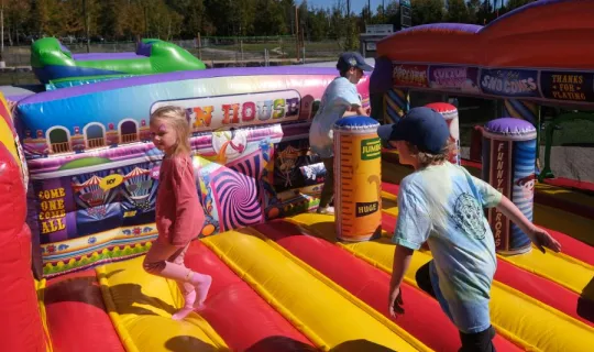 Children playing in a bouncy castle during NU Homecoming 2025