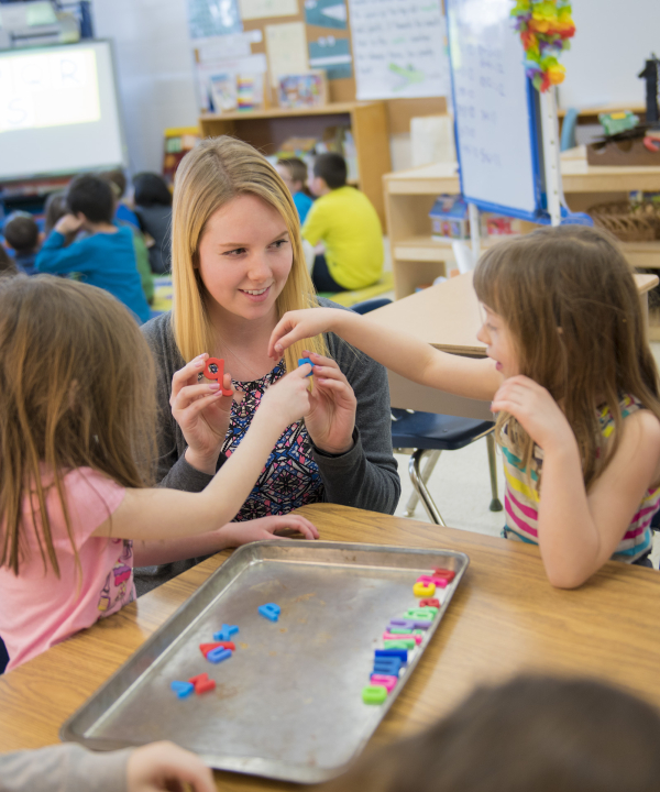 A teacher playing with some students in a classroom setting