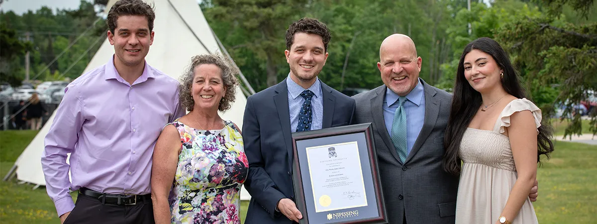 Family with graduate holding degree frame