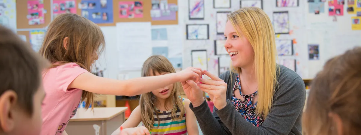 Teacher showing kindergarteners plastic alphabet letters