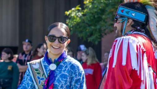 two pow wow participants donning Indigenous regalia.